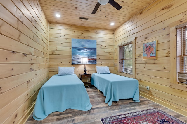 bedroom featuring dark hardwood / wood-style flooring, ceiling fan, wood walls, and wooden ceiling