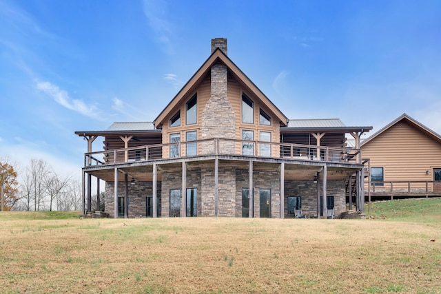 back of house featuring a wooden deck, a balcony, and a yard