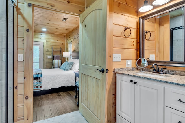 bathroom with wooden walls, hardwood / wood-style floors, wood ceiling, and vanity