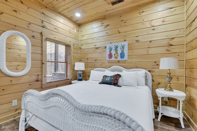 bedroom with dark hardwood / wood-style flooring and wood walls