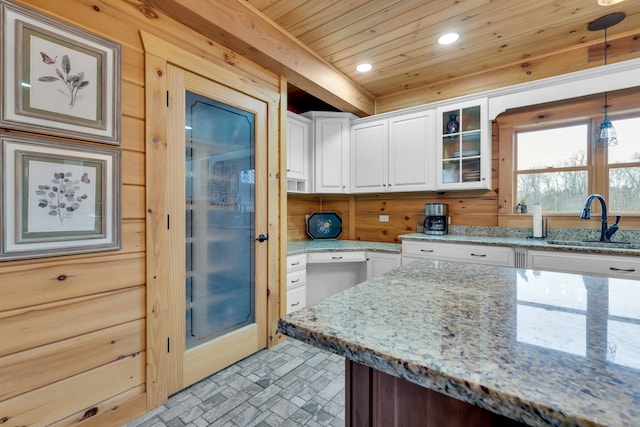 kitchen featuring wooden ceiling, white cabinetry, pendant lighting, light stone countertops, and sink