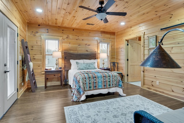 bedroom featuring ceiling fan, wooden walls, dark wood-type flooring, and wood ceiling