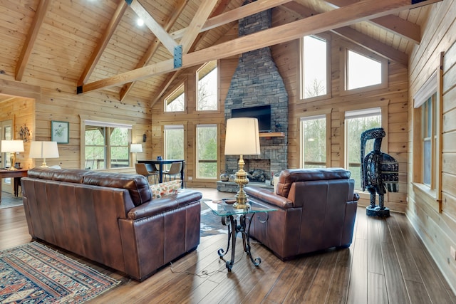 living room featuring wooden walls, wood ceiling, a stone fireplace, and hardwood / wood-style flooring