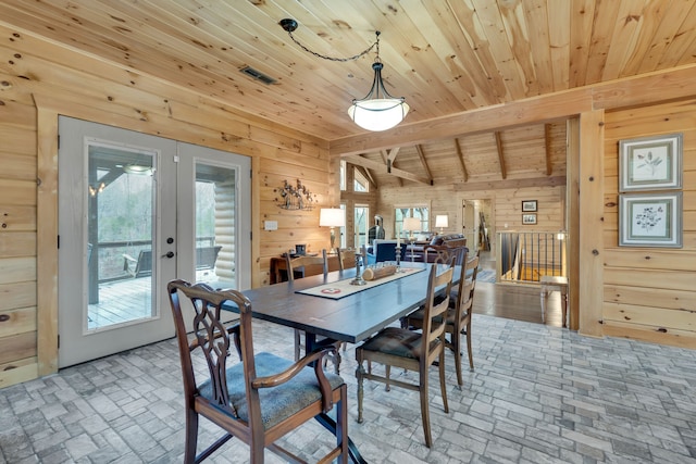 dining room featuring plenty of natural light, wood walls, wooden ceiling, and french doors