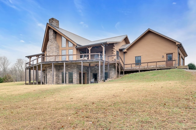 back of house featuring a wooden deck and a lawn