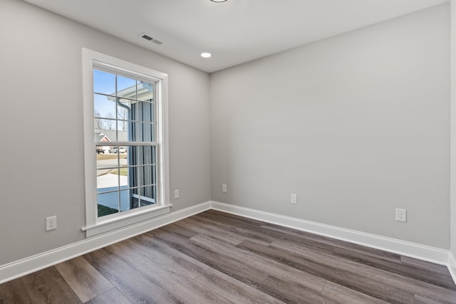 empty room with a healthy amount of sunlight and dark wood-type flooring