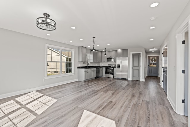 unfurnished living room with light hardwood / wood-style floors and sink