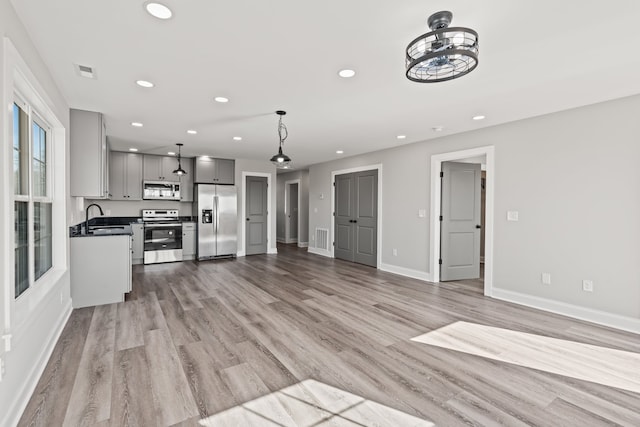 unfurnished living room with light hardwood / wood-style flooring and sink