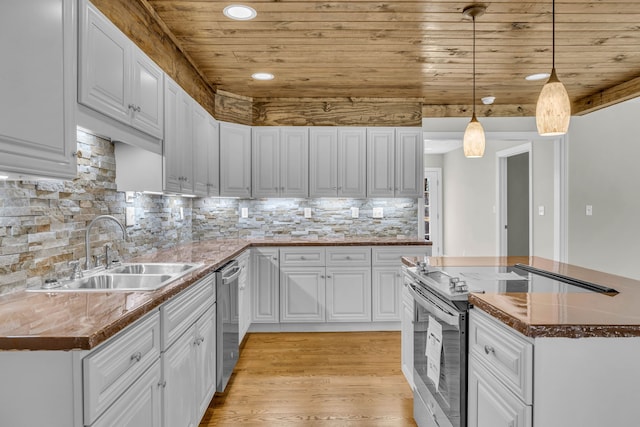 kitchen with white cabinetry, appliances with stainless steel finishes, light hardwood / wood-style floors, sink, and pendant lighting