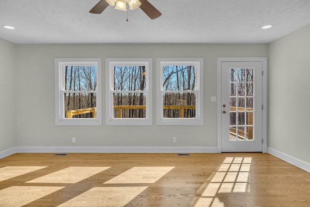 spare room with plenty of natural light, light hardwood / wood-style floors, and ceiling fan