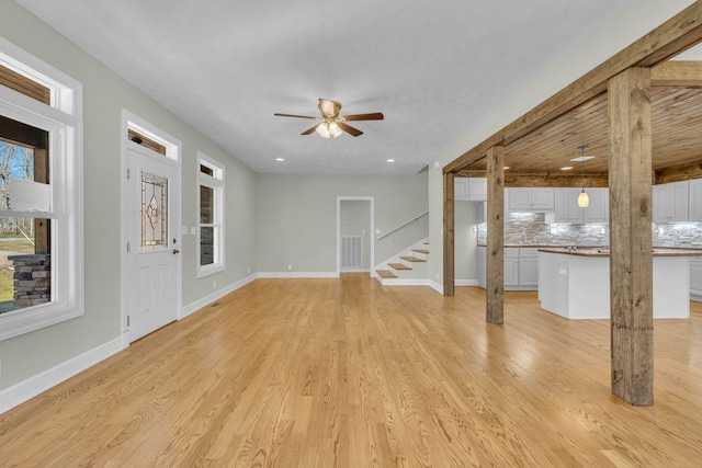 empty room with ceiling fan, light wood-type flooring, and a wealth of natural light