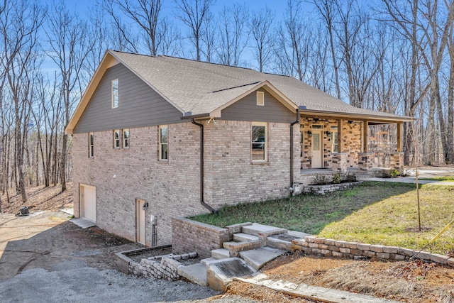 view of front of home with a porch, a front lawn, and a garage