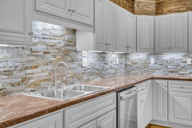 kitchen featuring backsplash, sink, white cabinetry, and stainless steel dishwasher