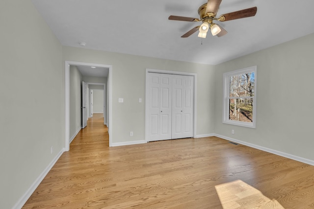 unfurnished bedroom with a closet, light hardwood / wood-style floors, and ceiling fan