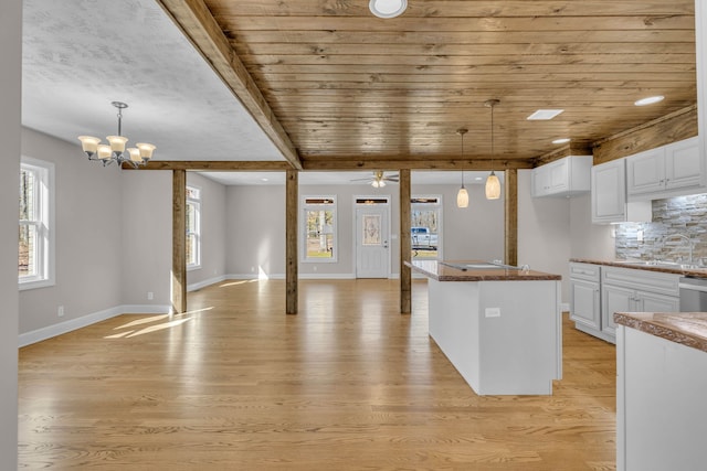 kitchen featuring plenty of natural light, white cabinets, pendant lighting, and light hardwood / wood-style flooring