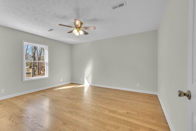 spare room with a textured ceiling, light hardwood / wood-style floors, and ceiling fan