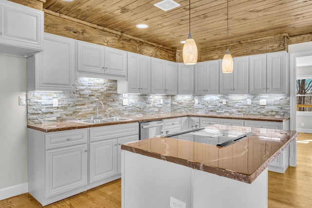 kitchen with sink, white cabinets, light hardwood / wood-style flooring, decorative light fixtures, and a center island