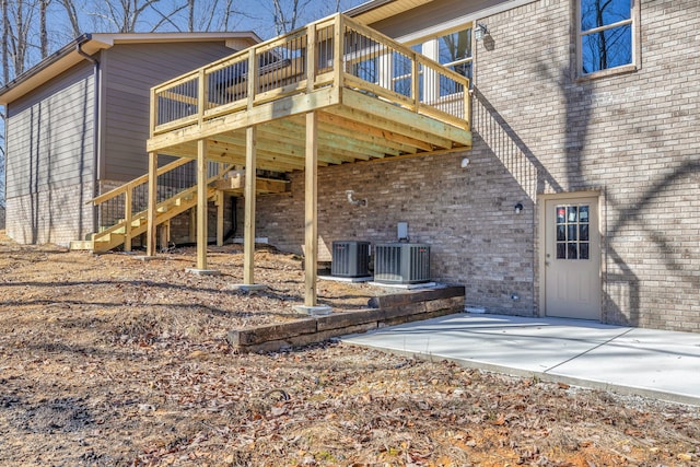 back of house with central AC unit, a deck, and a patio