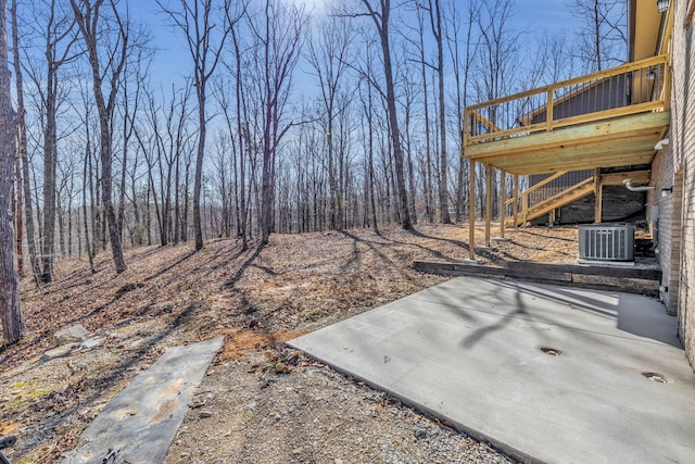 view of yard featuring a wooden deck, a patio area, and central air condition unit