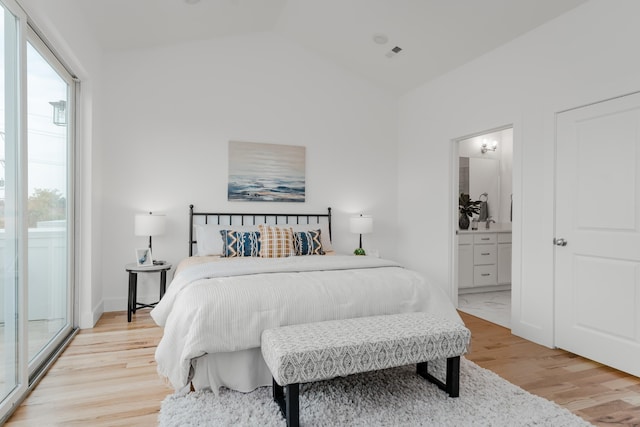 bedroom featuring lofted ceiling, connected bathroom, and light wood-type flooring