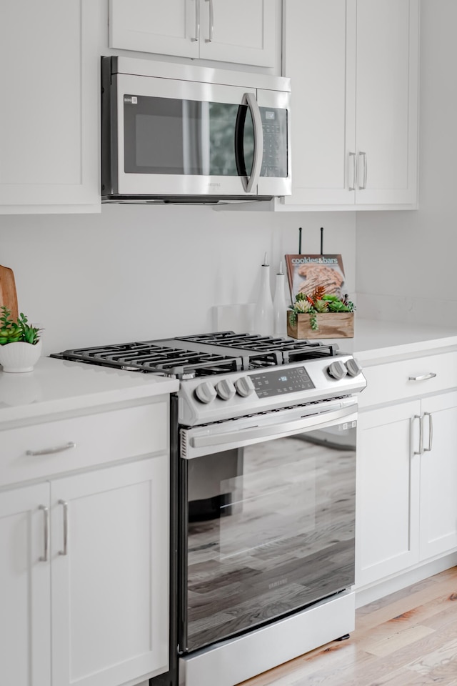 kitchen featuring white cabinetry, light hardwood / wood-style flooring, and stainless steel appliances