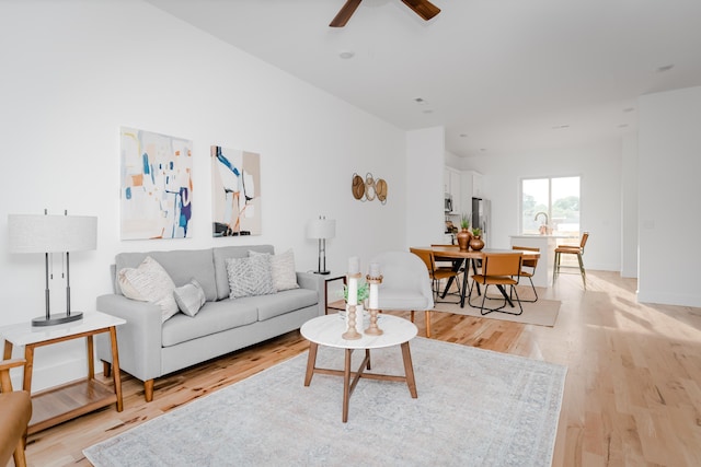 living room featuring ceiling fan and light wood-type flooring