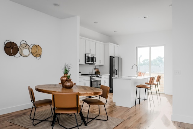 dining room with light hardwood / wood-style floors and sink