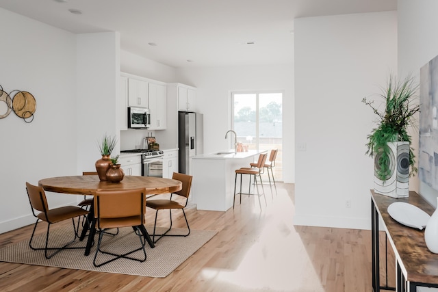 dining room featuring sink and light hardwood / wood-style flooring