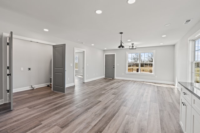 unfurnished living room featuring a wealth of natural light and light wood-type flooring