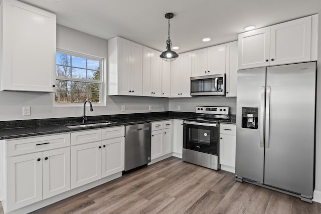 kitchen with white cabinetry, stainless steel appliances, and hardwood / wood-style floors