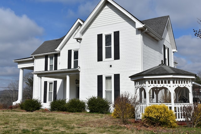 view of front of property with a porch, a front lawn, and a gazebo