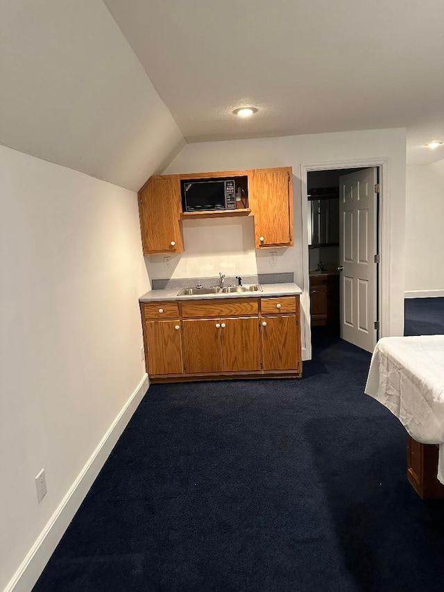 kitchen with black microwave, sink, lofted ceiling, and dark colored carpet