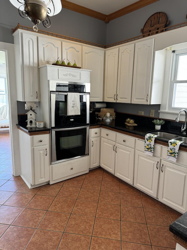 kitchen with tile patterned floors, sink, white cabinets, and stainless steel double oven