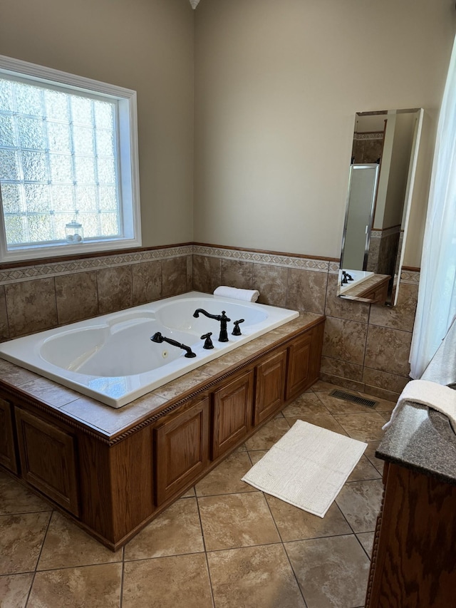 bathroom featuring tile patterned flooring, plus walk in shower, and tile walls