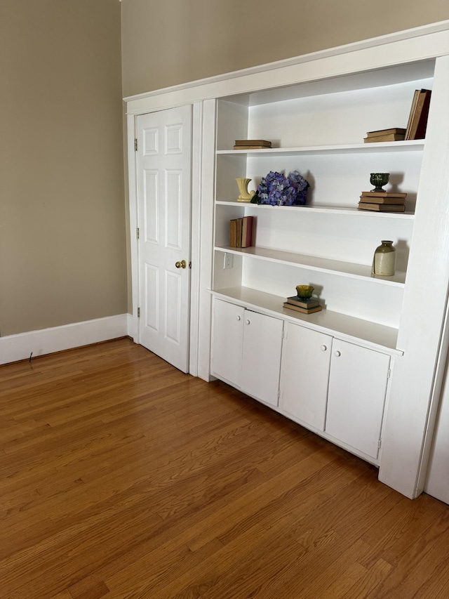 bar with white cabinets and wood-type flooring