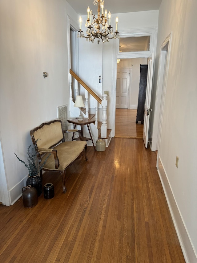 hallway featuring hardwood / wood-style flooring and a notable chandelier