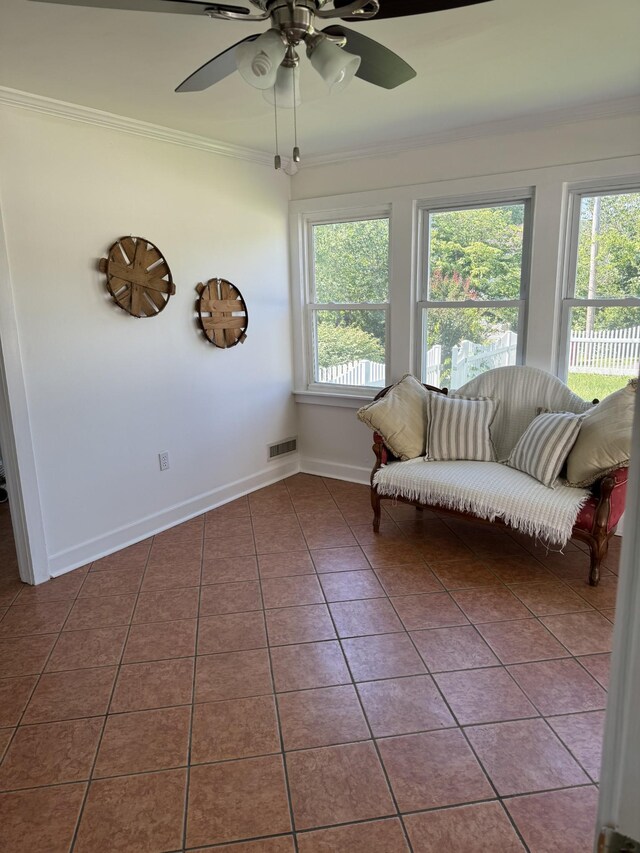 unfurnished room featuring dark tile patterned floors, ornamental molding, and ceiling fan