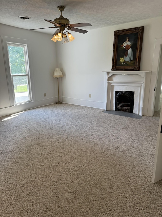 unfurnished living room with a textured ceiling, carpet floors, and ceiling fan