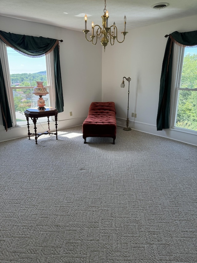 living area featuring carpet flooring, a notable chandelier, and a healthy amount of sunlight