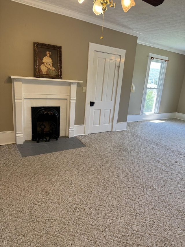 unfurnished living room featuring carpet, ceiling fan, ornamental molding, and a textured ceiling