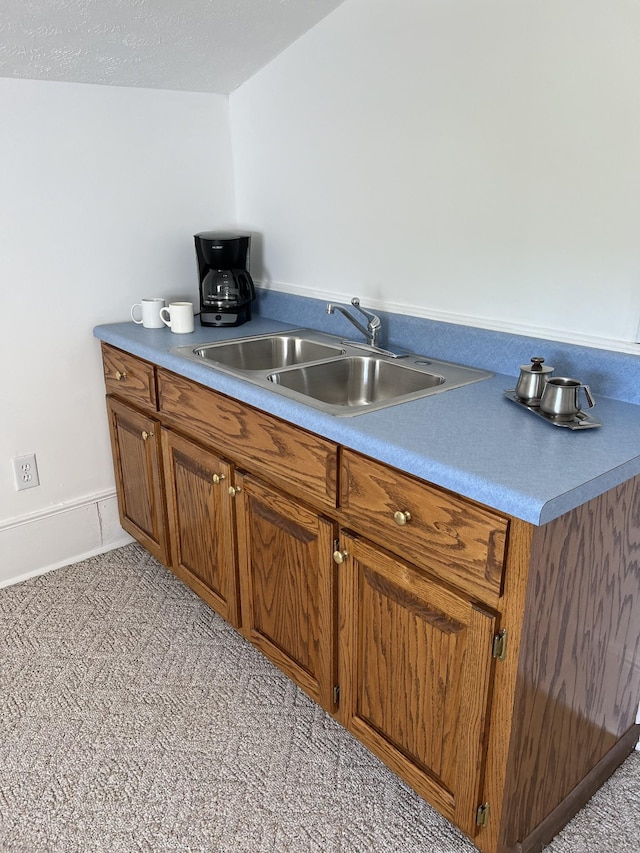 kitchen featuring a textured ceiling and sink