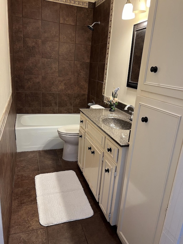 full bathroom featuring tile patterned flooring, vanity, toilet, and tiled shower / bath combo