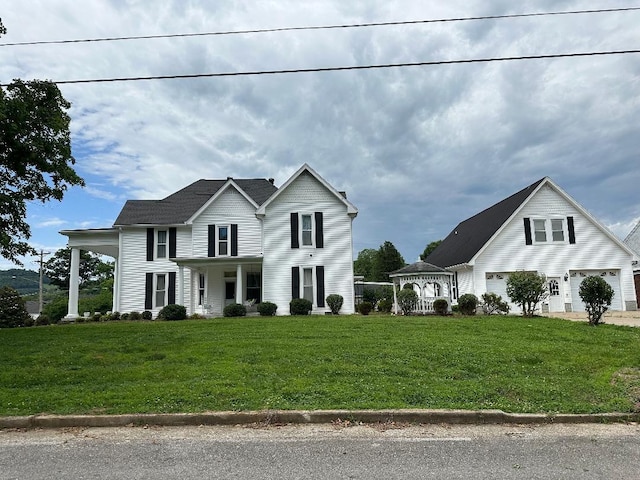 view of front of home featuring a porch, a garage, and a front yard