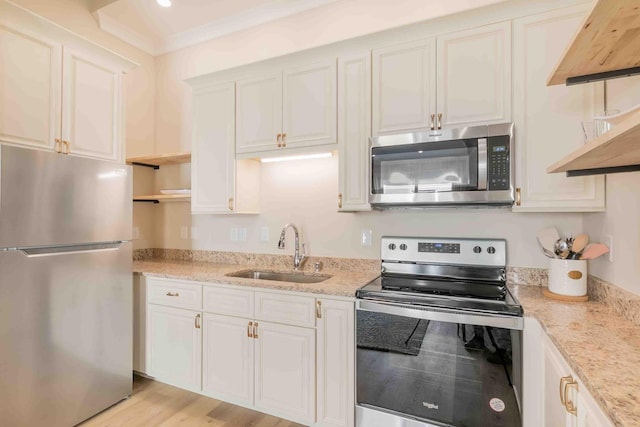 kitchen featuring white cabinets, sink, stainless steel appliances, light stone countertops, and light hardwood / wood-style floors