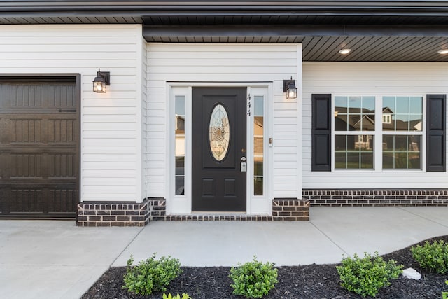 entrance to property featuring a porch and a garage