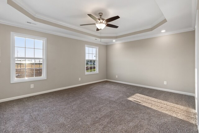 spare room featuring a tray ceiling, carpet floors, crown molding, and ceiling fan