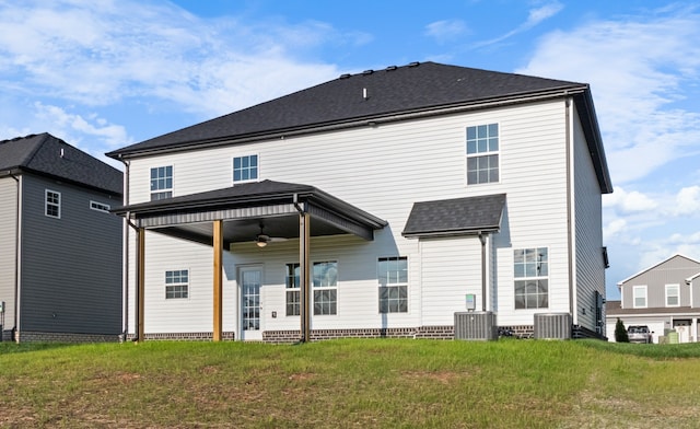 back of property featuring ceiling fan, a lawn, and central air condition unit