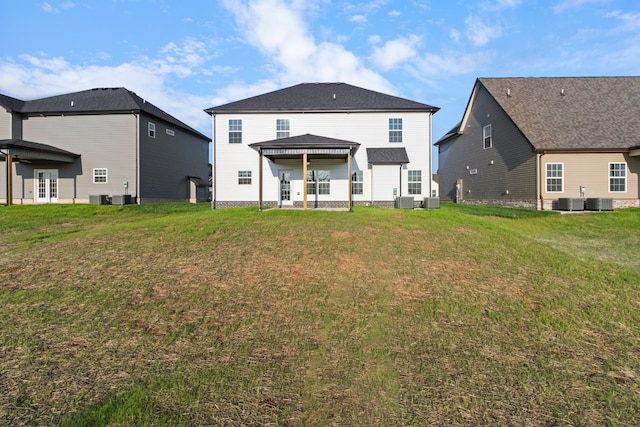 back of house featuring a yard and central air condition unit