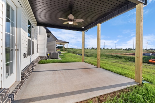 view of patio / terrace featuring central AC, ceiling fan, and a rural view