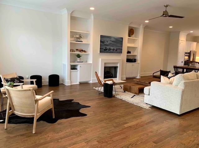 living room featuring ceiling fan, ornamental molding, and dark hardwood / wood-style floors